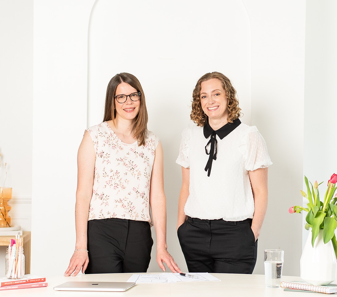 Andrea Krones and Kelley Gibson of Inkling Design standing behind a table