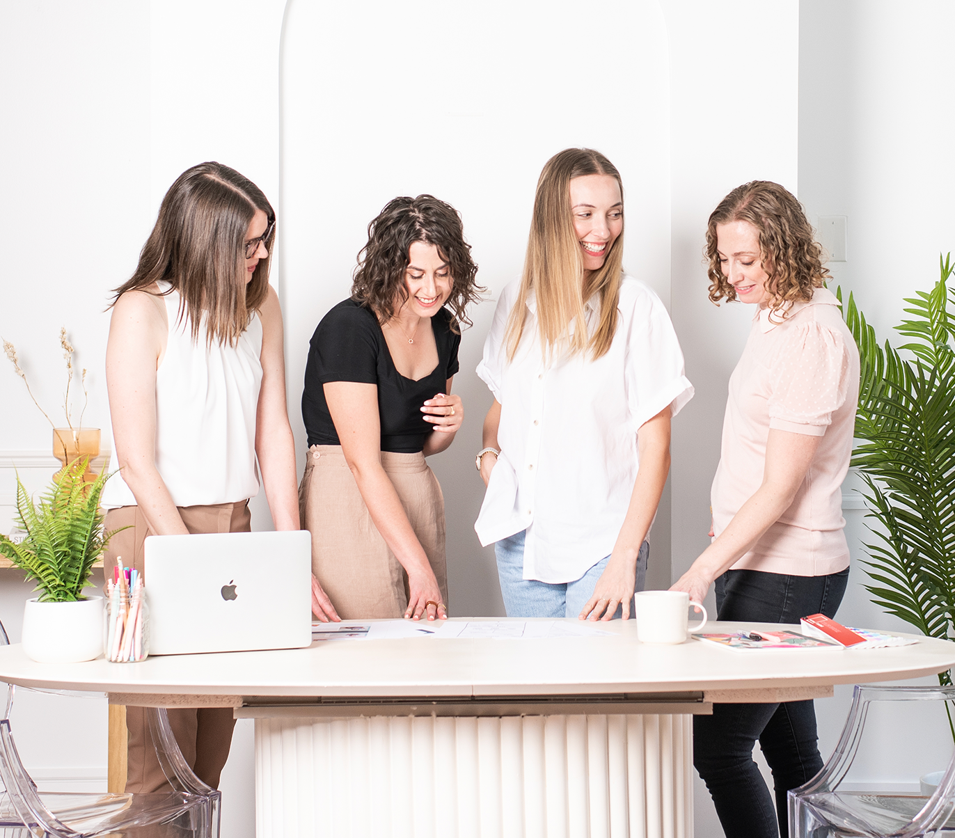 The Inkling Design team gathered around a desk collaborating on a project